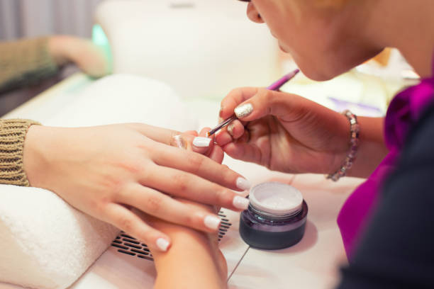 маникюр делает искусственные ногти в маникюрном салоне - nail salon fingernail manicure design стоковые фото и изображения
