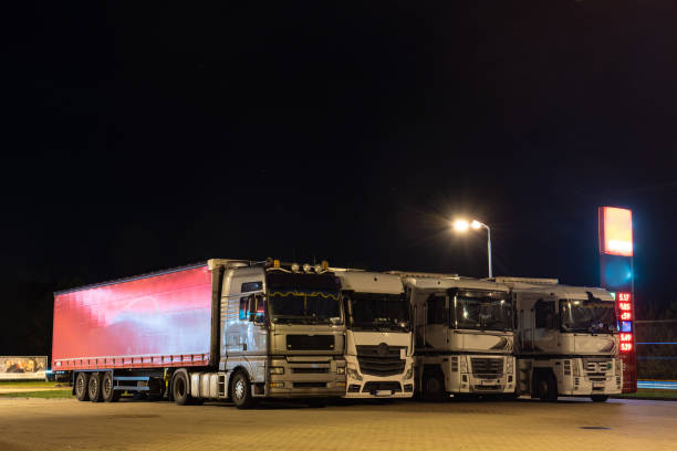 Big trucks at night in parking lot under lantern stock photo