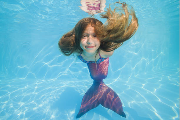 girl in a mermaid costume poses underwater in a pool. Young beautiful girl poses underwater in the pool. girl in a mermaid costume poses underwater in a pool. Young beautiful girl poses underwater in the pool. life stile stock pictures, royalty-free photos & images