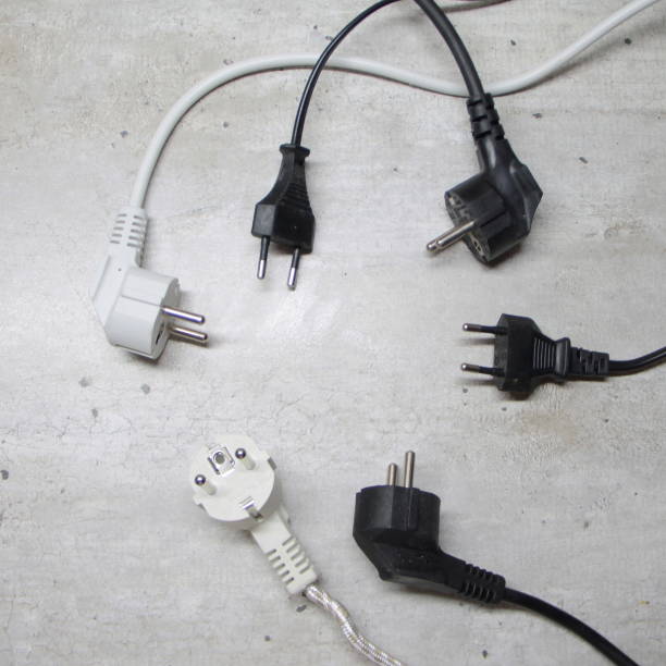 istock Electric plugs with cords lie on a gray surface in a circle 1202527818
