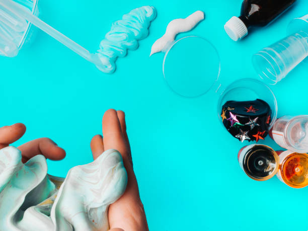 istock Components to make slime. Child education concept. On blue surface slime, toothpaste, shaving foam, decorative accessories, color paints on blue background 1202530260