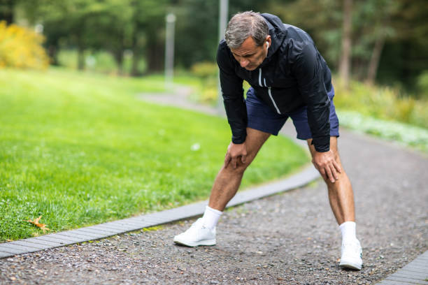 istock Senior man stretching before jogging alone in public park on autumn morning 1202530638