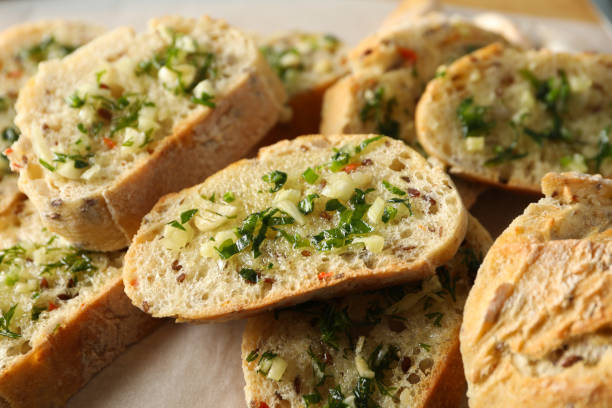 istock Toasted garlic bread slices on baking paper, close up 1202530767
