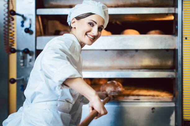 istock Baker putting bread in the bakery oven 1202532117