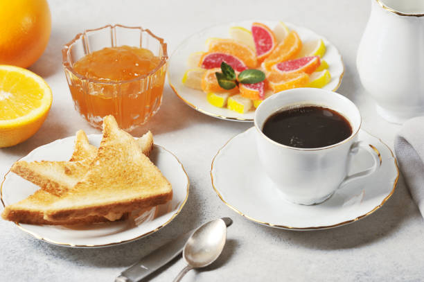 istock Table setting for breakfast. Toasts with orange jam, coffee, cream, marmalade. 1202532193