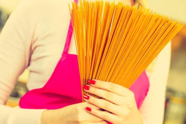 istock Woman holding long pasta 1202532221
