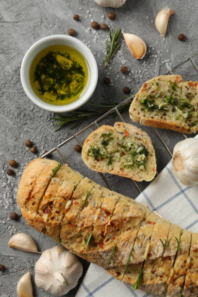 istock Tasty garlic bread and spices on grey background, top view 1202532583