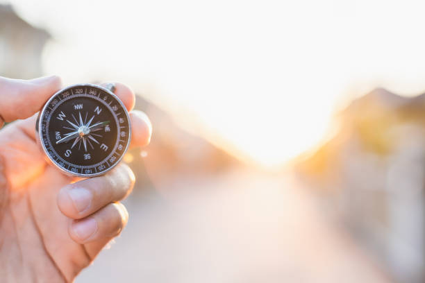 istock man holding compass on blurred background. for activity lifestyle outdoors freedom or travel tourism and inspiration backpacker alone tourist travel or navigator image. 1202533994