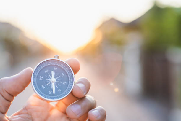 man holding compass on blurred background. for activity lifestyle outdoors freedom or travel tourism and inspiration backpacker alone tourist travel or navigator image. - compass symbol direction guide imagens e fotografias de stock