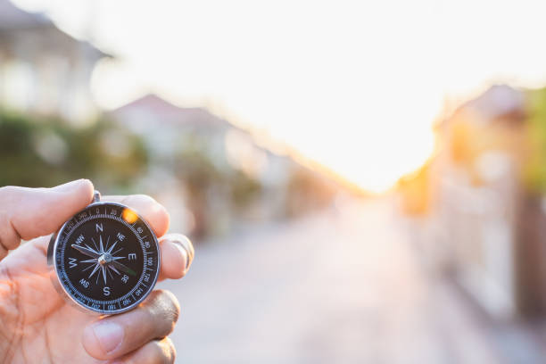 istock man holding compass on blurred background. for activity lifestyle outdoors freedom or travel tourism and inspiration backpacker alone tourist travel or navigator image. 1202534087