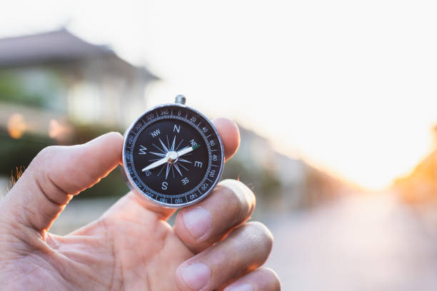 istock man holding compass on blurred background. for activity lifestyle outdoors freedom or travel tourism and inspiration backpacker alone tourist travel or navigator image. 1202534156