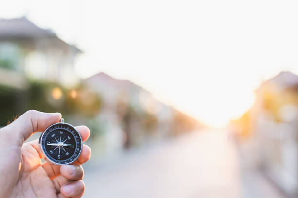 istock man holding compass on blurred background. for activity lifestyle outdoors freedom or travel tourism and inspiration backpacker alone tourist travel or navigator image. 1202534181