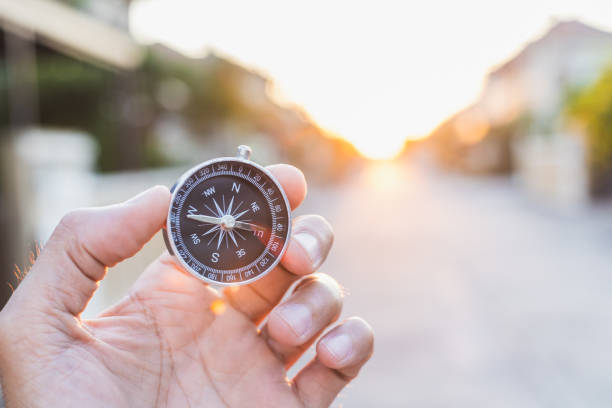 istock man holding compass on blurred background. for activity lifestyle outdoors freedom or travel tourism and inspiration backpacker alone tourist travel or navigator image. 1202534771