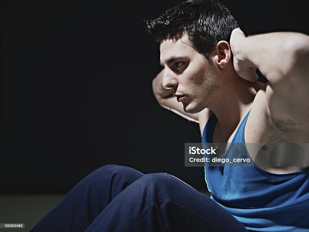 Homme faire des séries de sit-ups sur fond noir - Photo de Activité libre de droits