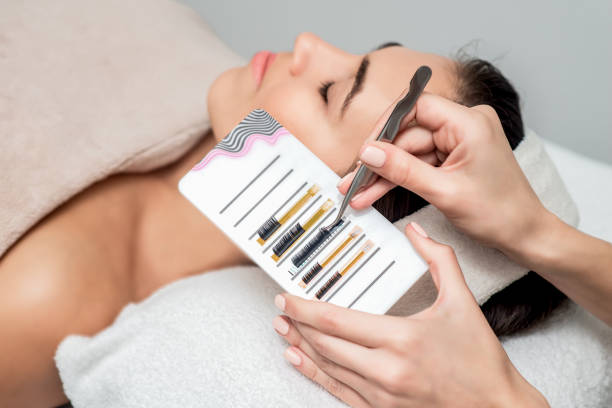 istock Beautician taking eyelashes by tweezers. 1202535989