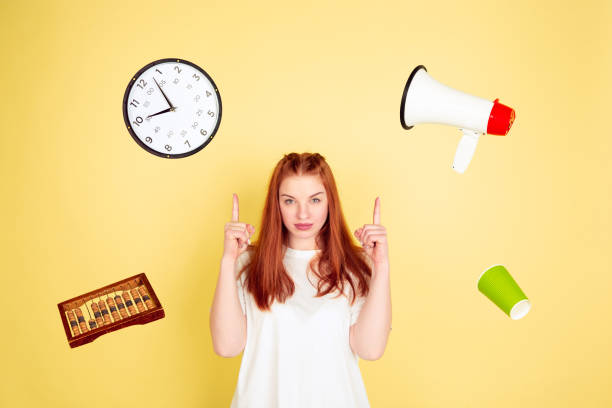 istock Caucasian young woman's portrait on yellow background, too much tasks 1202536523