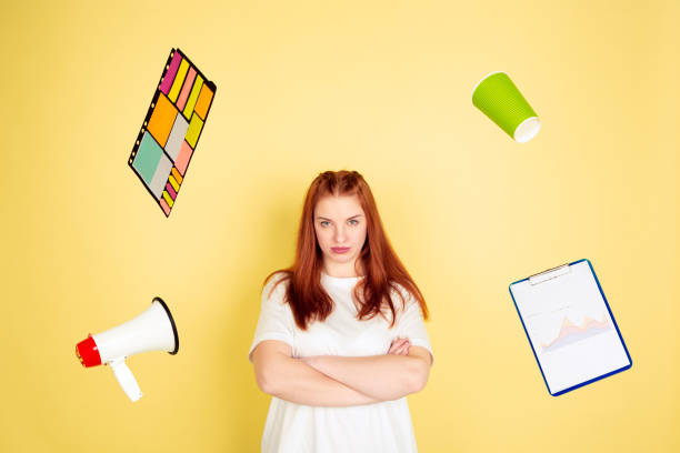istock Caucasian young woman's portrait on yellow background, too much tasks 1202536525