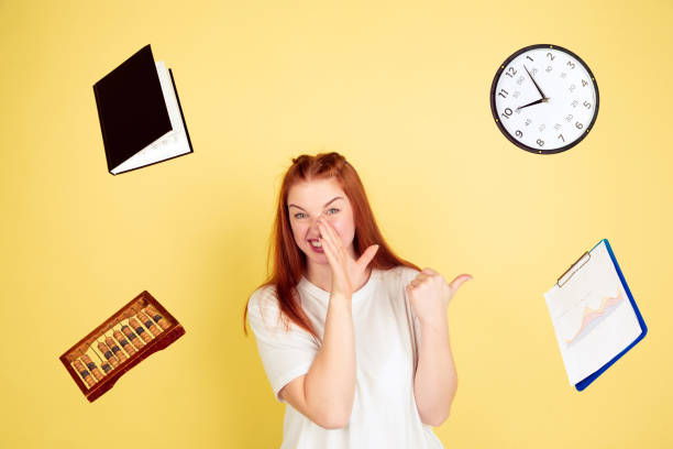 istock Caucasian young woman's portrait on yellow background, too much tasks 1202536596