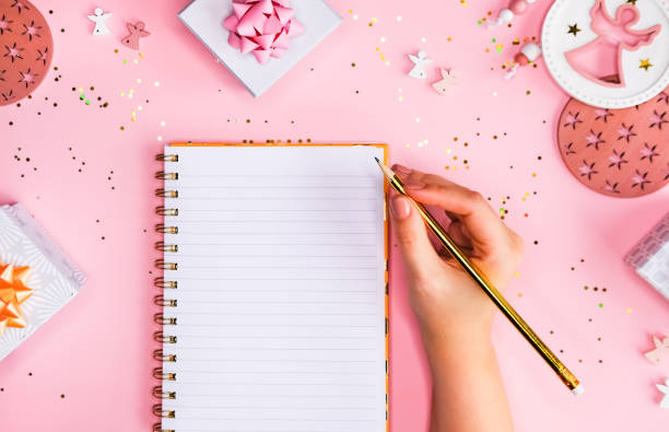 istock Golden Holiday decorations and notebook on pink background, flat lay style. Christmas planning concept. 1202537231