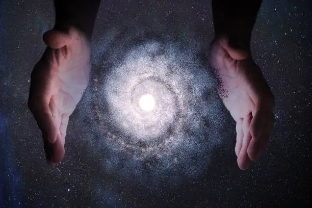 Photo of Creationism concept. Hands of God are creating Galaxy in universe.