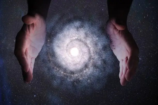 Creationism concept. Hands of God are creating Galaxy in universe.