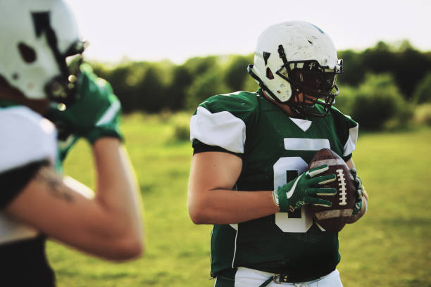 istock Football linebacker holding a ball during a team practice 1202538954