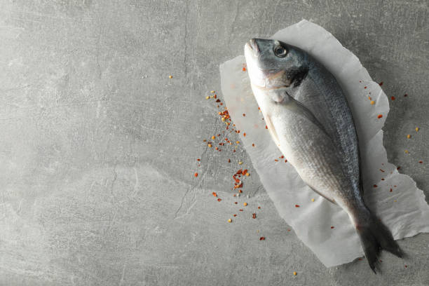 istock Baking paper with Dorado fish and spices on grey background, space for text 1202539040