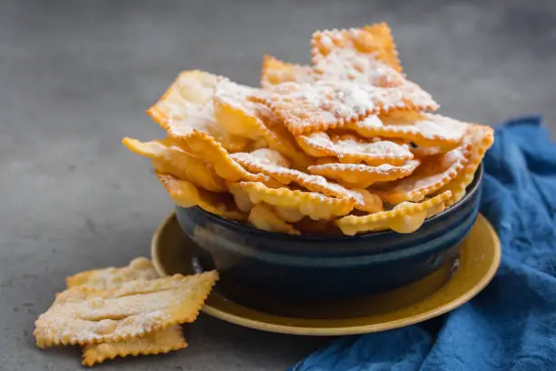 Homemade "sfrappole" or "chiacchiere". Italian traditional sweet crisp pastry  deep-fried and sprinkled with powdered sugar. Commonly eaten during Carnival and on Fat Thursday.