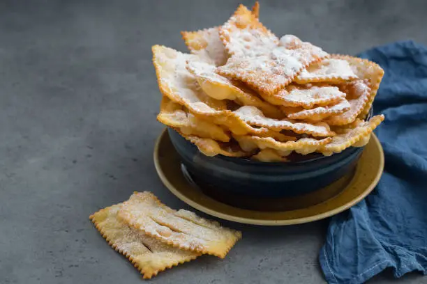 Homemade "sfrappole" or "chiacchiere". Italian traditional sweet crisp pastry  deep-fried and sprinkled with powdered sugar. Commonly eaten during Carnival and on Fat Thursday.