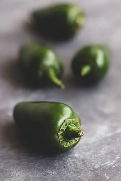 Raw and Organic Green Jalapeno Peppers on Dark Background