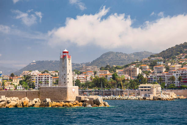 istock A lighthouse at sea with city in background. 1202540286