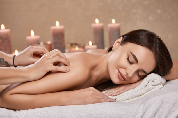 istock aroma theraphy with candles and massage for woman's back in spa salon 1202541549