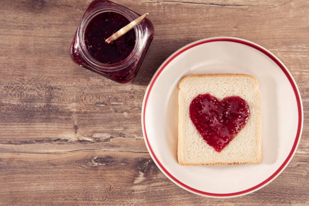 istock Heart Shaped Raspberry Jam on Brown Wooden Table 1202541736