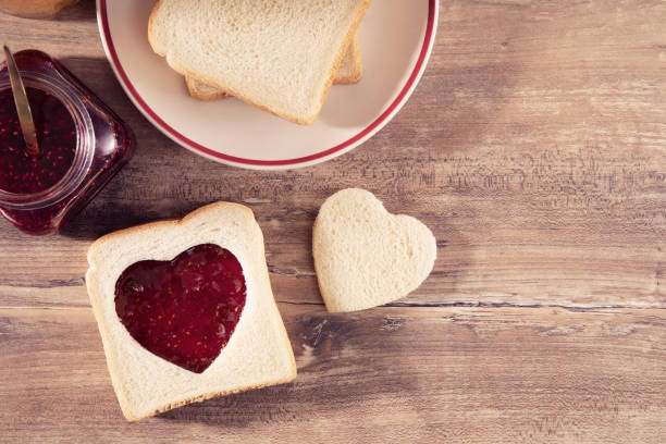istock Heart Shaped Raspberry Jam on Brown Wooden Table 1202543532