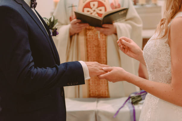 narzeczeni podczas ceremonii ślubnej umieścić obrączki na palcach - men suit holding human finger zdjęcia i obrazy z banku zdjęć