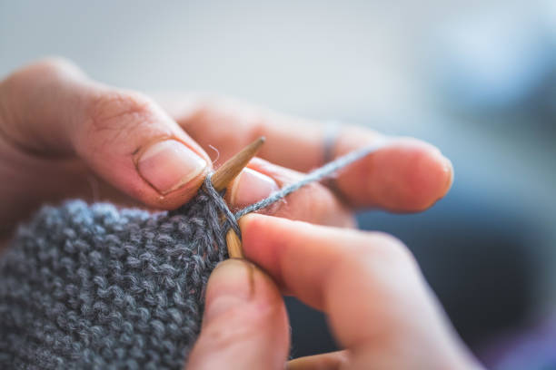 istock Knitting at home: Close up of wool, thread and female fingers 1202546399