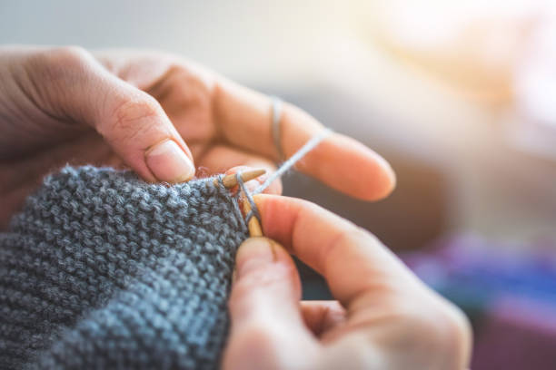 istock Knitting at home: Close up of wool, thread and female fingers 1202546435