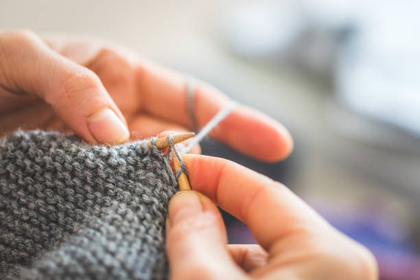istock Knitting at home: Close up of wool, thread and female fingers 1202546510