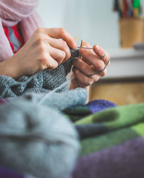 istock Knitting at home: Close up of wool, thread and female fingers 1202546526