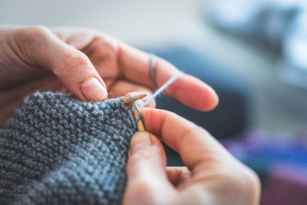 istock Knitting at home: Close up of wool, thread and female fingers 1202546616