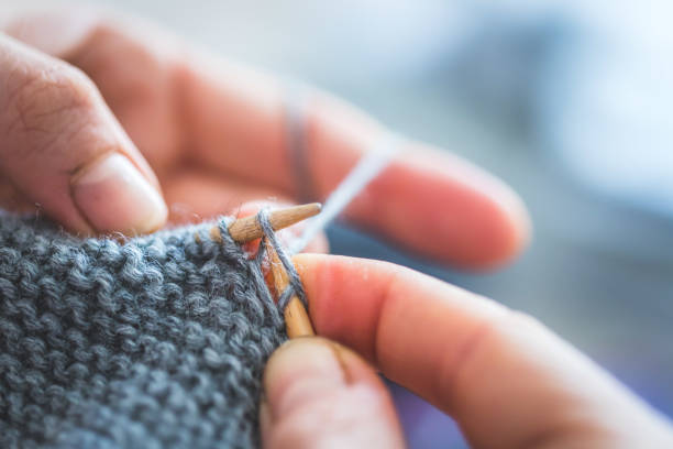 istock Knitting at home: Close up of wool, thread and female fingers 1202546620