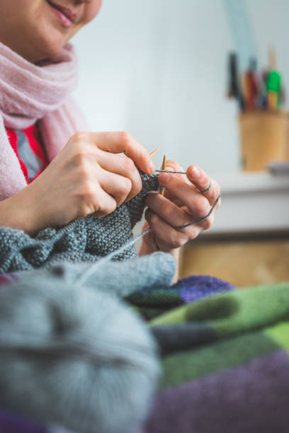 istock Knitting at home: Close up of wool, thread and female fingers 1202546653