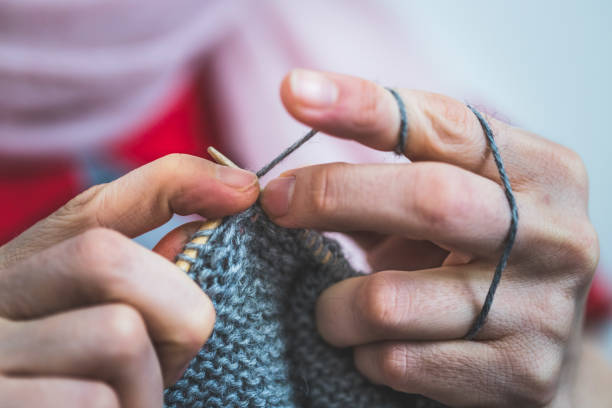 istock Knitting at home: Close up of wool, thread and female fingers 1202546689