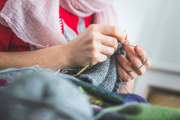 istock Knitting at home: Close up of wool, thread and female fingers 1202546843