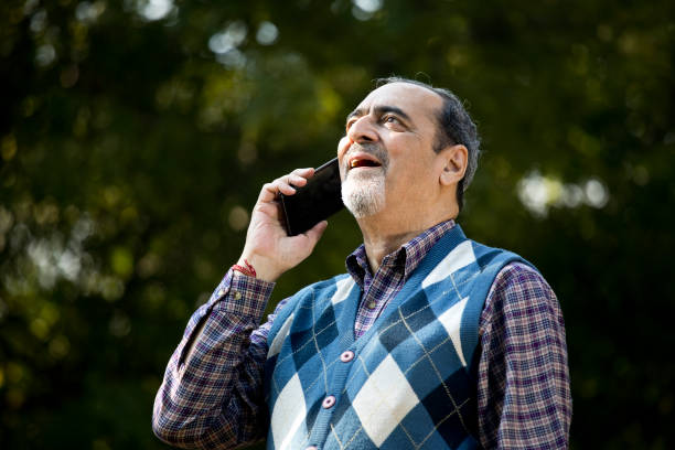 istock Happy senior man using phone at park 1202548300