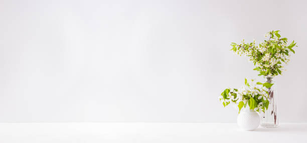 istock Home interior with decor elements. Spring flowers in a vase on a light background 1202550243