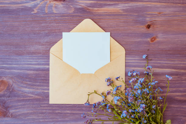 istock Mockup white wedding invitation and envelope with blue flowers on on a wooden table 1202550274