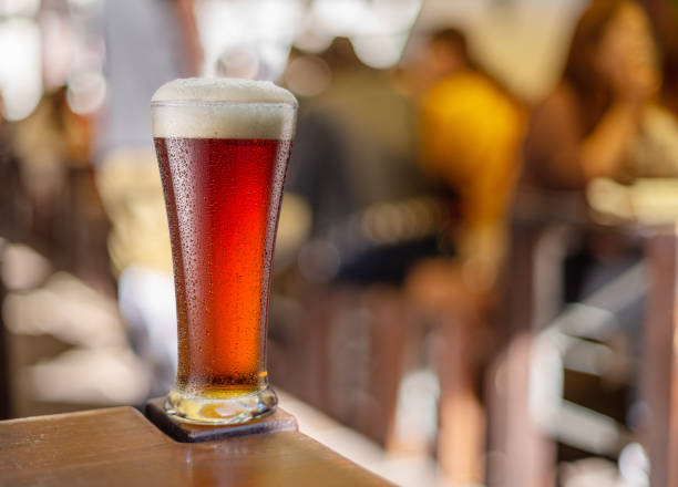 Glass of beer stands on a table in a pub. Red beer.