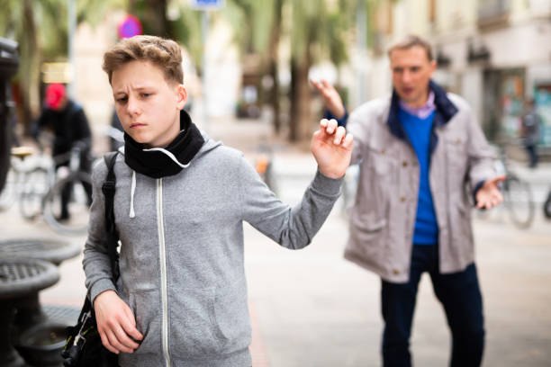 istock Frowning teenager gesturing enough while man reprimanding him 1202550885
