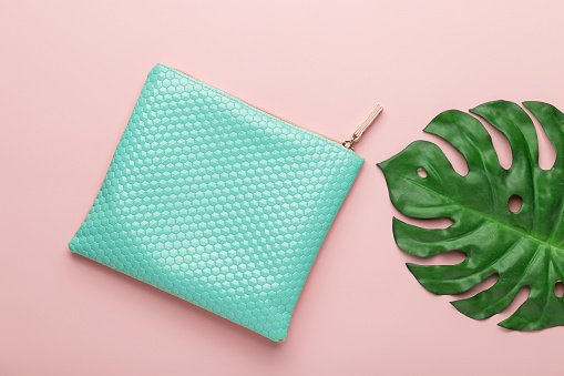 Purse and leaves monstera flat lay top view. Minimal fashion concepts